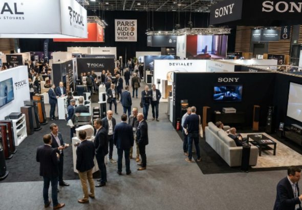 Exhibitor booths showcasing hi-fi speakers and home cinema systems on the show floor at the Paris Audio Video Show 2026 in the Palais des Congrès de Paris