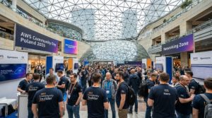 AWS Heroes and community builders networking with attendees in the sponsor demo area during AWS Community Day Poland 2026 at the Złote Tarasy venue in central Warsaw